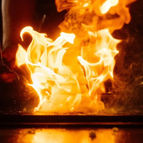 Flames rising from the hibachi grill during the fire show