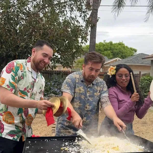 Guests playing drums and cymbals during a backyard hibachi party show