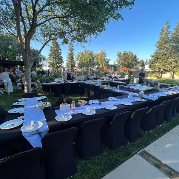 Black-draped party tables set up on a backyard lawn